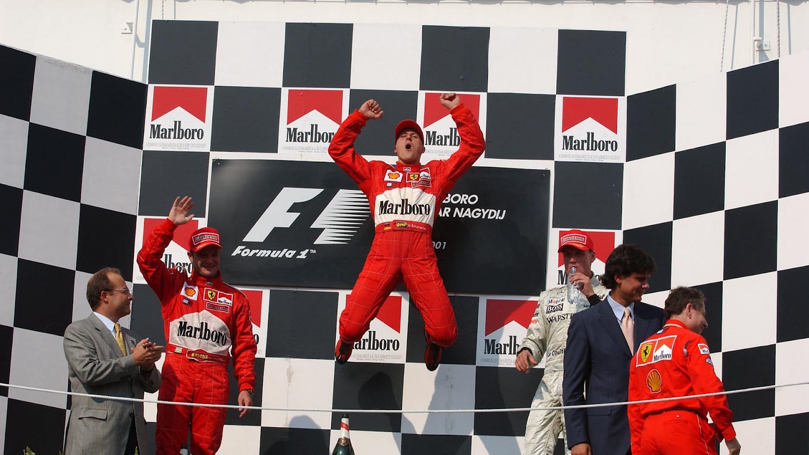 Micheal Schumacher jumps in celebration at the top of the podium